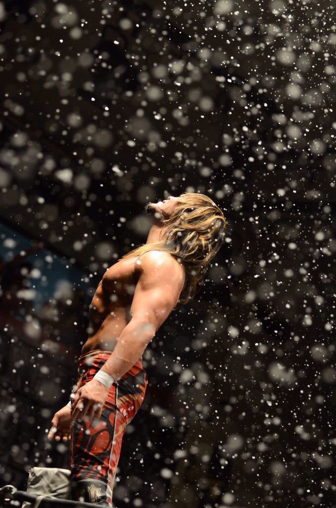Hiroshi Tanahashi standing on the turnbuckle at Korakuen Hall at the end of 2015 as snow falls around him to celebrate the end of the year in NJPW.